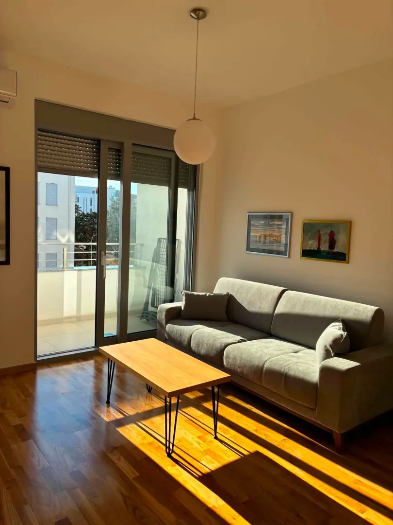 Living room with a sofa, coffee table and access to the terrace.
