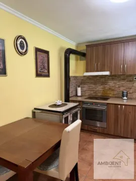 Kuhinja sa drvenim elementima, štednjakom na drva i trpezarijskim stolom. - image 14