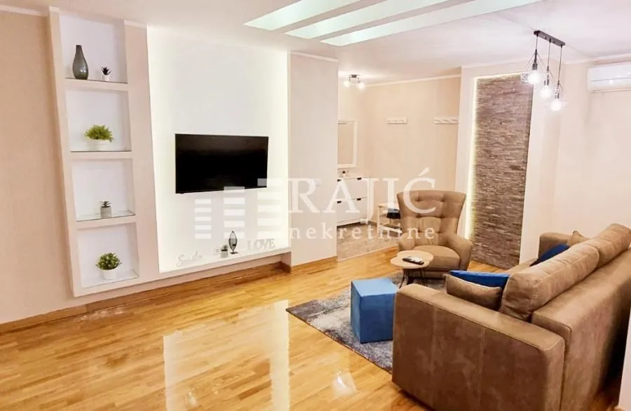 Spacious living room with a sofa and TV.