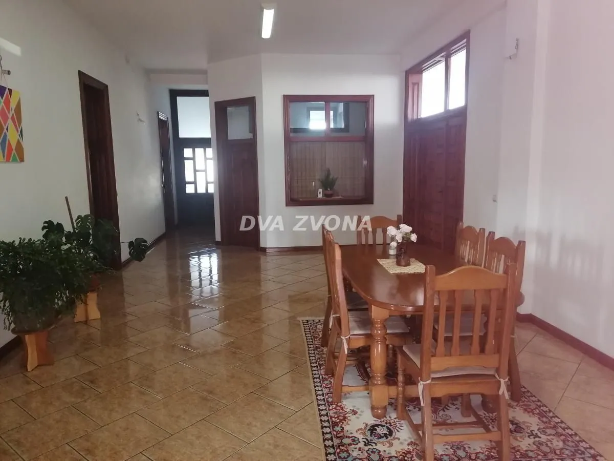 Spacious living room with a dining table and tiled flooring.
