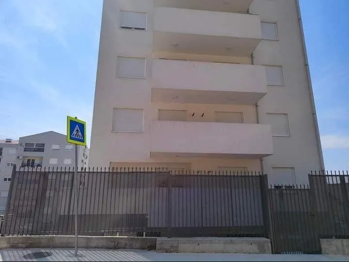 View of the exterior of an apartment building with a fence.