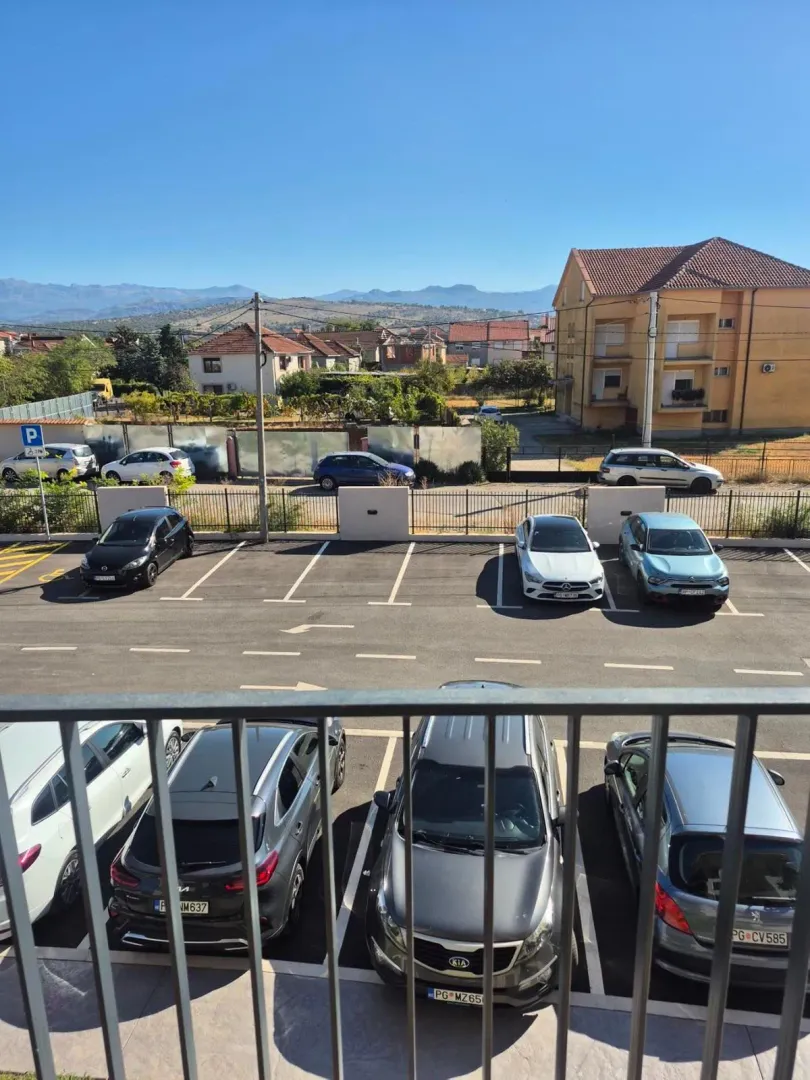 Pogled sa terase na parking i okolne zgrade.