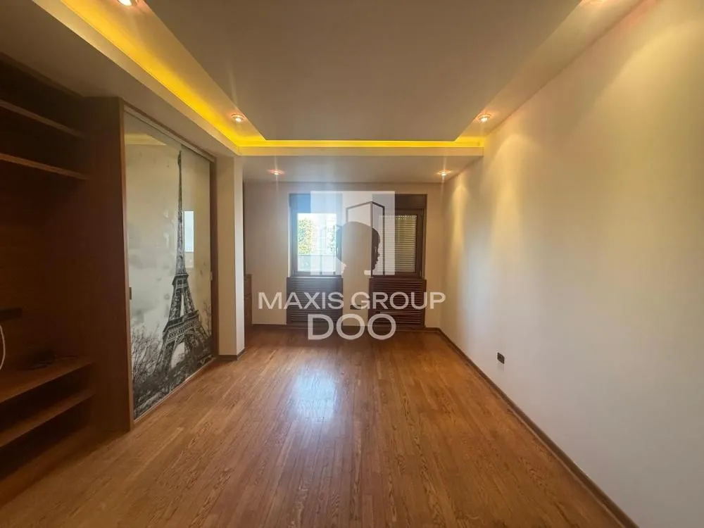 Empty room with wooden flooring and a built-in wardrobe.