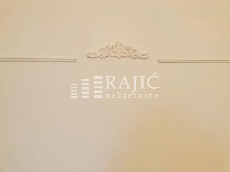 Wall detail with decorative molding and an agency watermark.