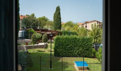 Pogled iz prozora na uređen zeleni vrt i dvorište. - image 13