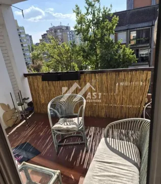 Manji namešteni balkon sa garniturom za sedenje i pogledom na grad. - image 8