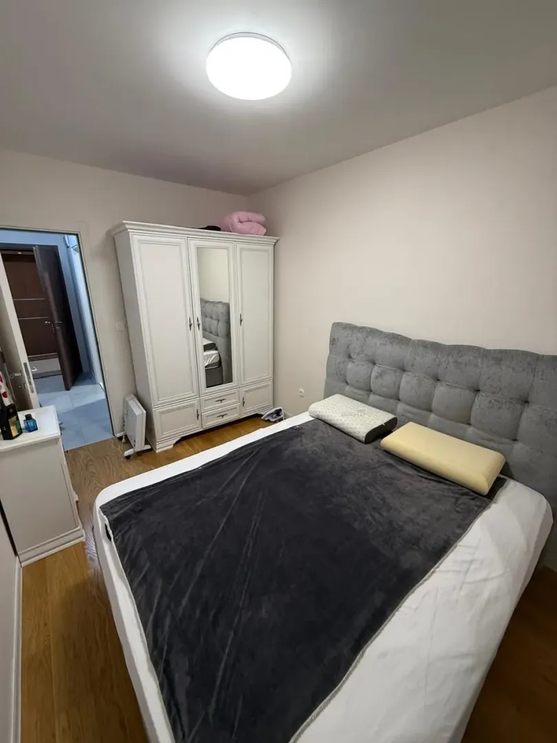 Furnished bedroom with a double bed and a wardrobe.