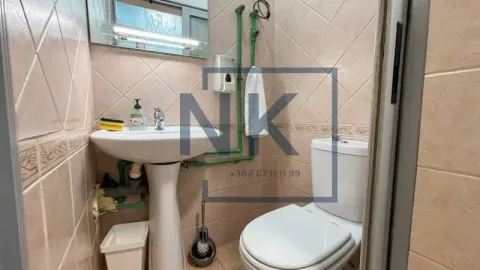 Small tiled bathroom with a sink and a toilet. - image 2