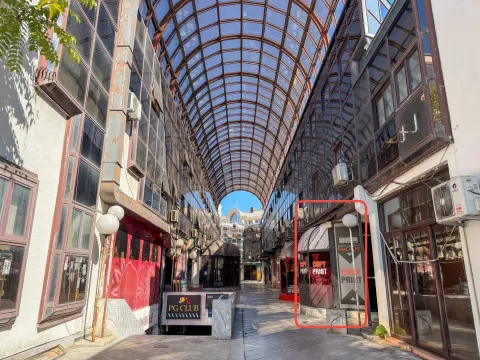 View of a covered passageway with a glass roof and commercial spaces. - image 2