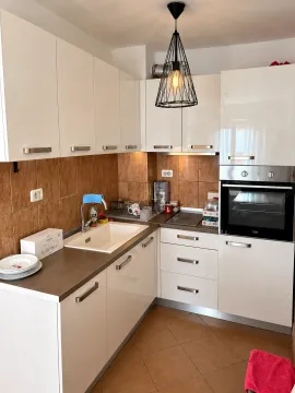 Compact white kitchen with a sink, built-in oven, and ceramic wall tiles. - image 4