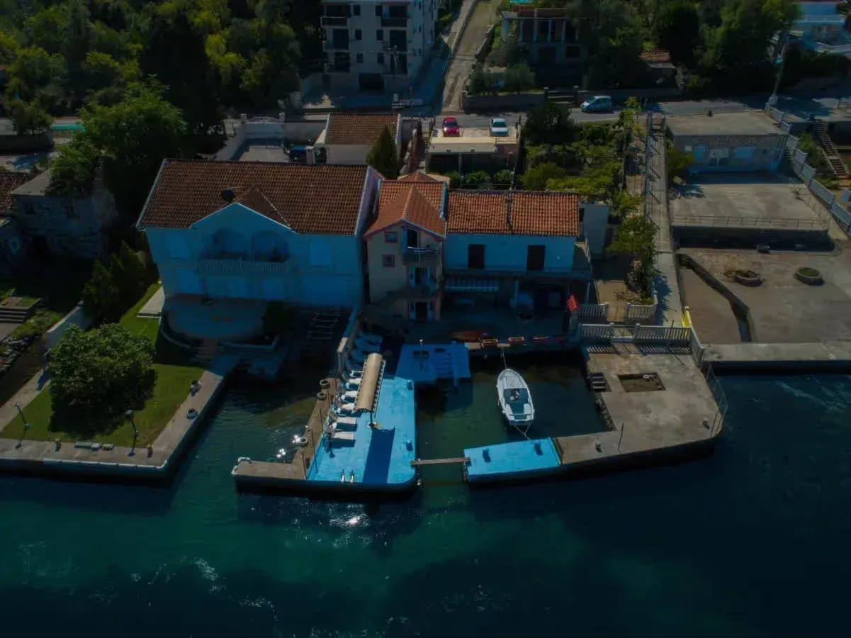 Pogled iz vazduha na kuću na obali mora sa sopstvenim pristaništem i vezom za brod.