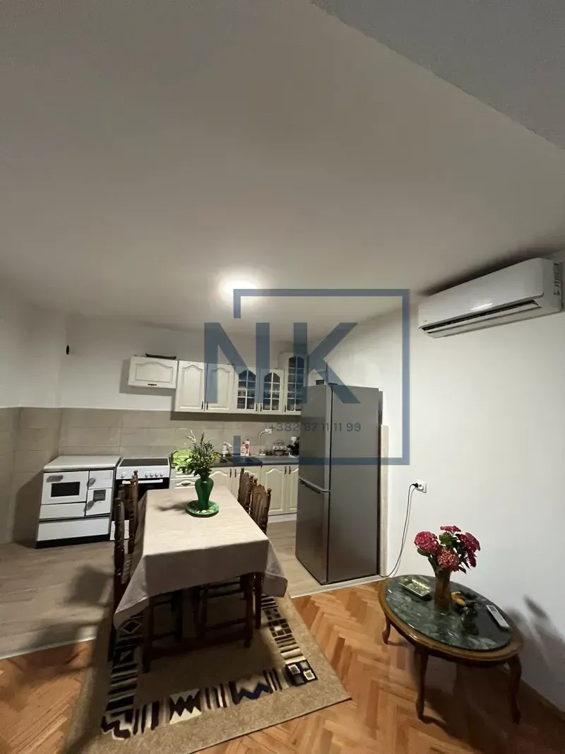 Kitchen with dining area equipped with appliances and a wooden table.