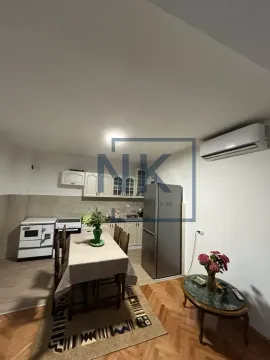 Kitchen with dining area equipped with appliances and a wooden table. - image 3