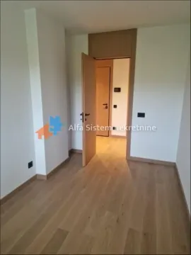 Empty room with hardwood flooring and an open door leading to the hallway. - image 8