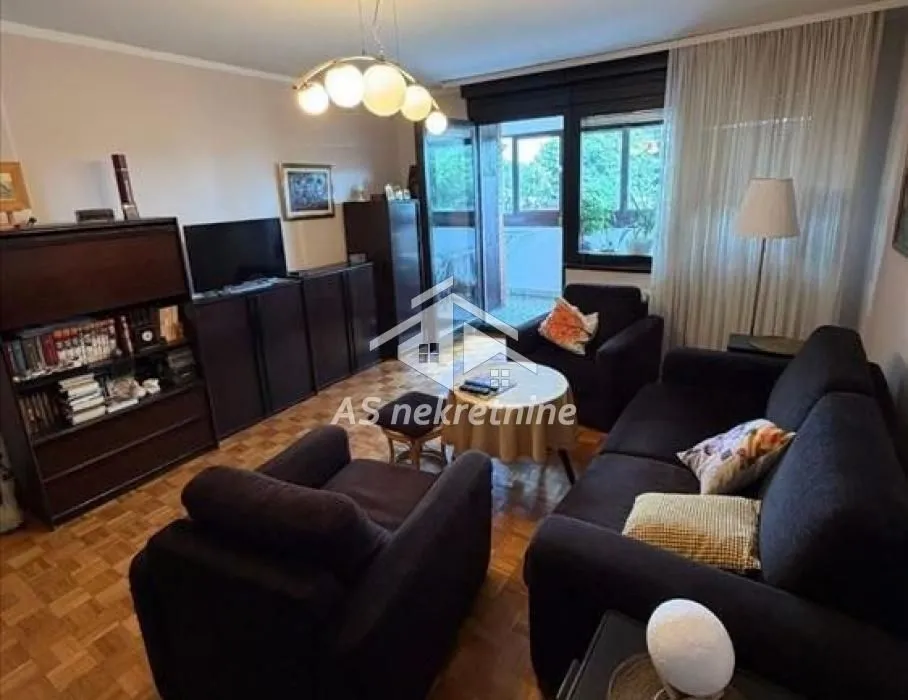 Living room with sofa set, TV, and access to the terrace.