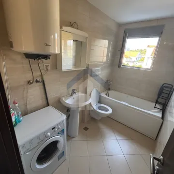Fully equipped bathroom with a bathtub, sink, toilet, and washing machine. - image 8