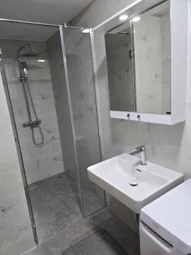 Modernly equipped bathroom with a walk-in shower and washbasin. - image 6