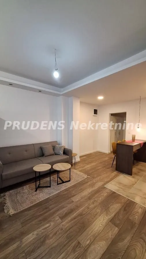 Dnevna soba sa garniturom i trpezarijskim delom u pozadini.