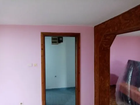 View of interior rooms with pink walls and wooden door frames. - image 11