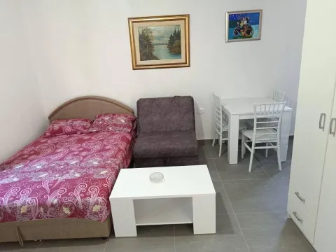 Furnished bedroom with a bed, armchair, and dining table. - image 4
