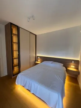 Modern bedroom with a double bed, built-in wardrobe, and ambient lighting. - image 7