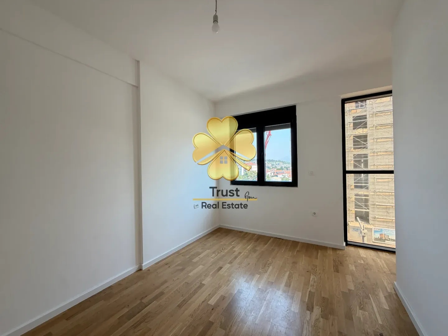 Empty room with white walls and wooden flooring.
