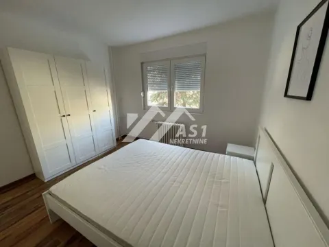 Spavaća soba sa bračnim krevetom, belim garderoberom i prozorom. - image 7