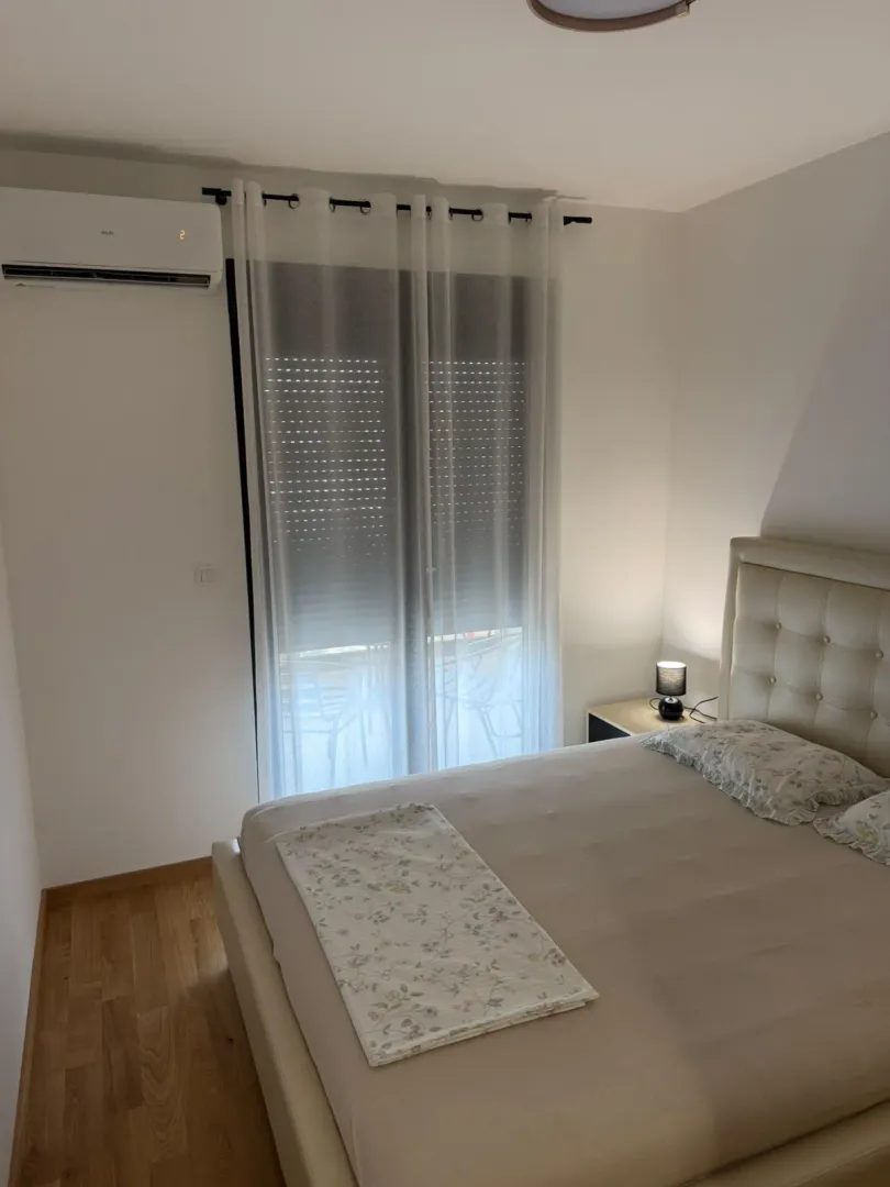 Bedroom with a double bed, nightstand, and air conditioning unit.