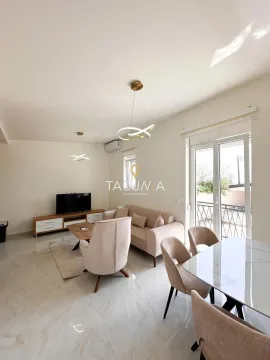 Living room with a sofa set, television, and dining table. - image 6