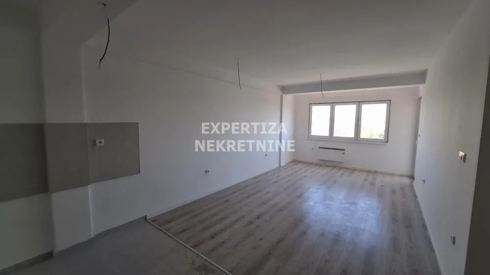 Empty room with laminate flooring and windows.