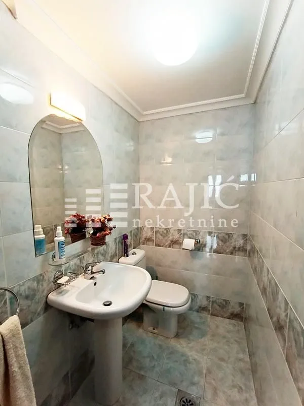 Smaller bathroom with a sink, mirror, and toilet.