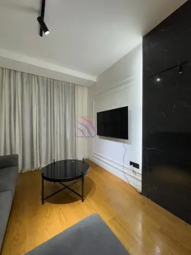 Living room with a sofa, coffee table and wall-mounted TV. - image 5