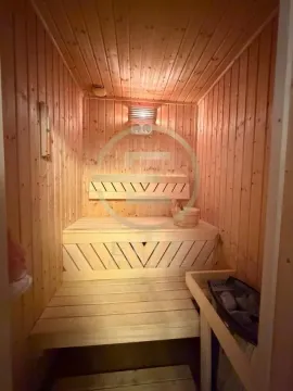 Unutrašnjost drvene saune sa klupama i peći sa kamenjem. - image 29