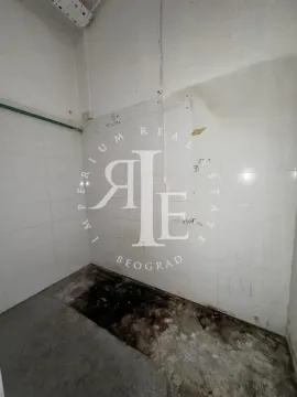 Empty room with white wall tiles and a rough floor. - image 19