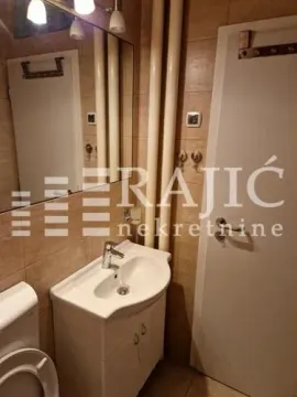 Small bathroom with a sink, mirror, and toilet bowl. - image 11