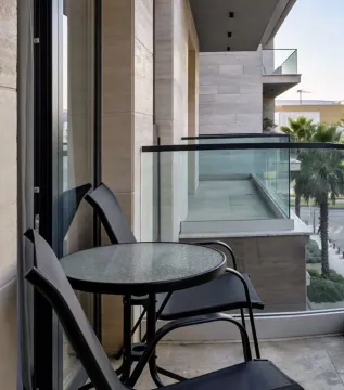 Moderan balkon sa garniturom za sedenje i pogledom na okolinu. - image 12