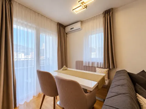 Living room with a dining table, sofa, and large windows. - image 11