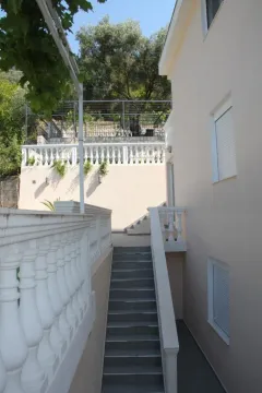 Spoljašnji pogled na stepenište i fasadu kuće sa terasom. - image 3