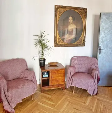 Living room with two armchairs, a small table, and a painting on the wall. - image 4