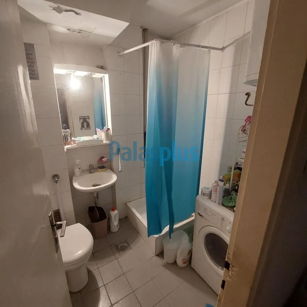 Manje kupatilo sa tuš kabinom, umivaonikom, WC šoljom i veš mašinom.