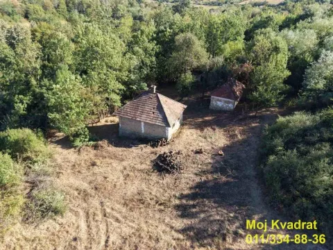 Pogled iz vazduha na stare kuće okružene zelenilom i šumom. - image 2