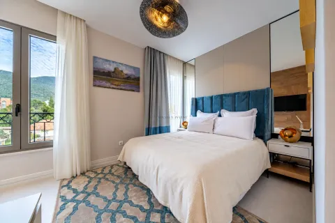Modern bedroom with a double bed, blue headboard, and access to the terrace. - image 16