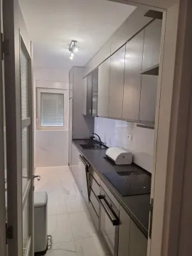 Moderna i uska kuhinja sa sivim elementima i svijetlim pločicama. - image 10