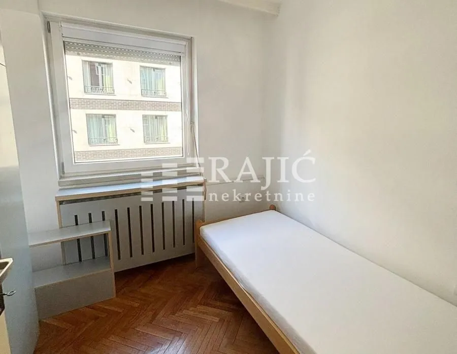 Small bedroom with a bed and window.