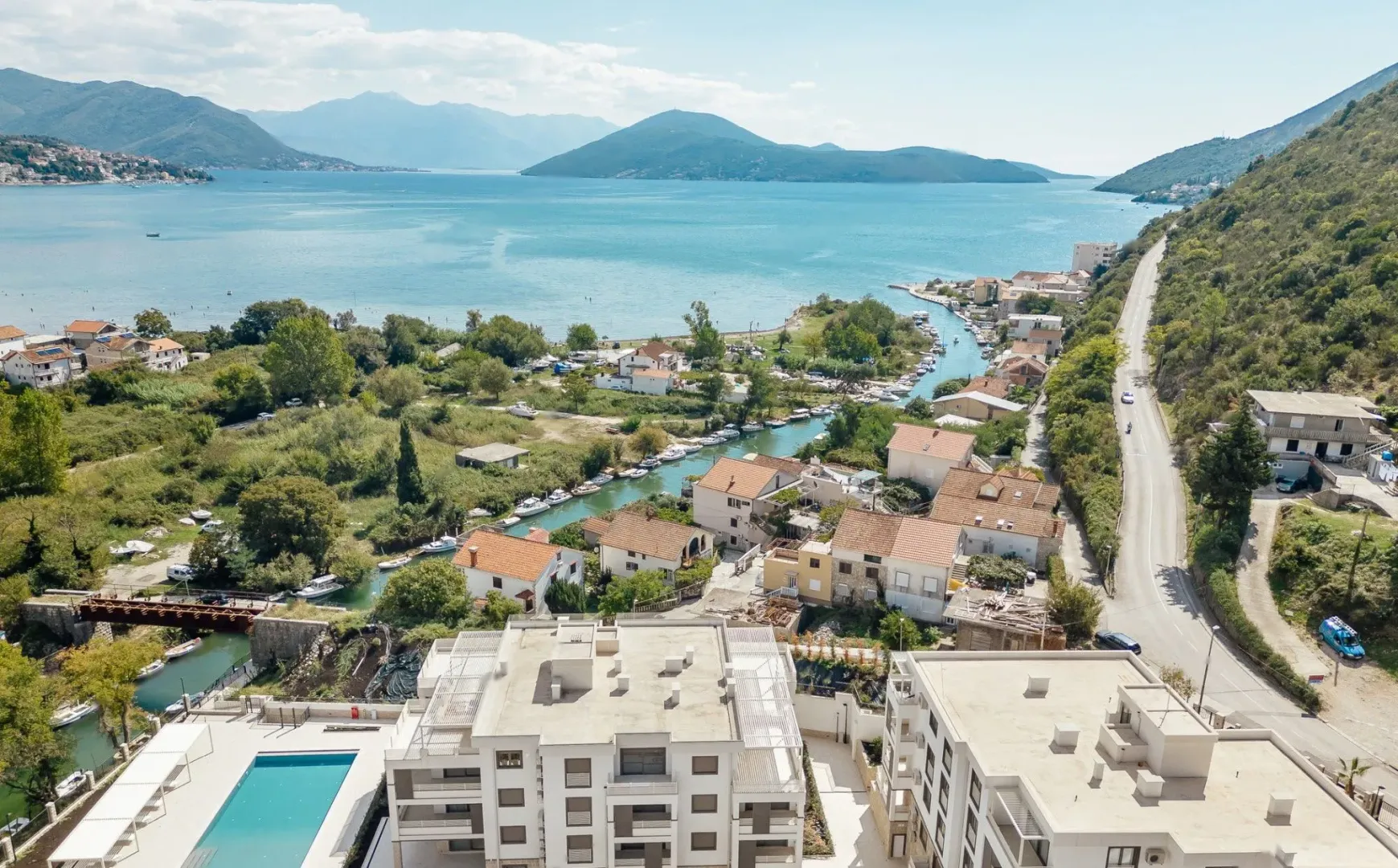 Pogled iz vazduha na zaliv, naselje i okolne planine.