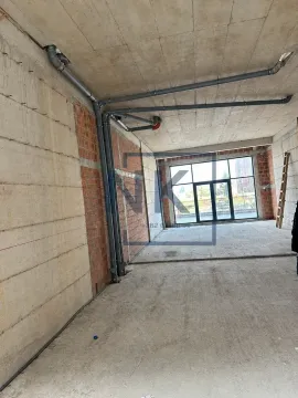 Unfinished space under construction with exposed pipes and a large window. - image 2
