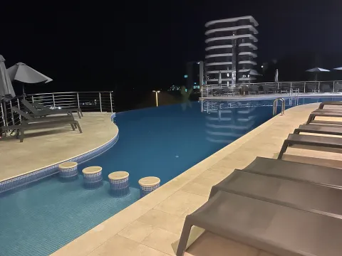 Pogled noću na vanjski bazen sa ležaljkama i terasom. - image 24