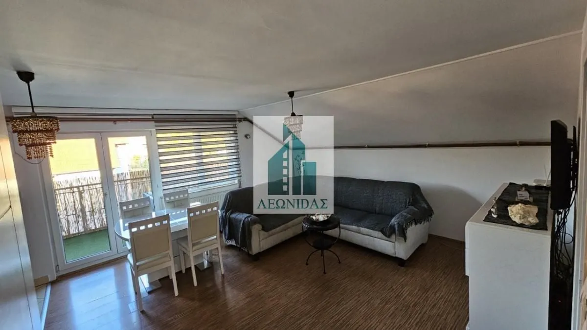 Living room with a sofa set and dining table, with access to the terrace.