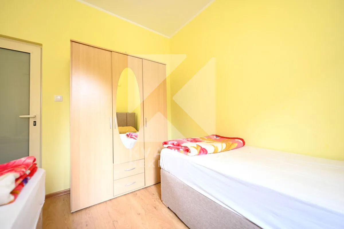 A bedroom with a bed and a wooden wardrobe.