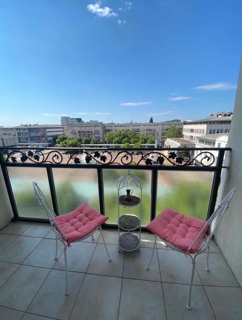 Namješten balkon sa dvije stolice i pogledom na grad.